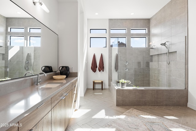 bathroom featuring vanity, plenty of natural light, and tiled shower