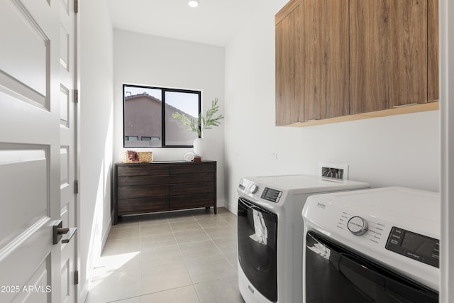 laundry area with cabinets, washer and clothes dryer, and light tile patterned floors