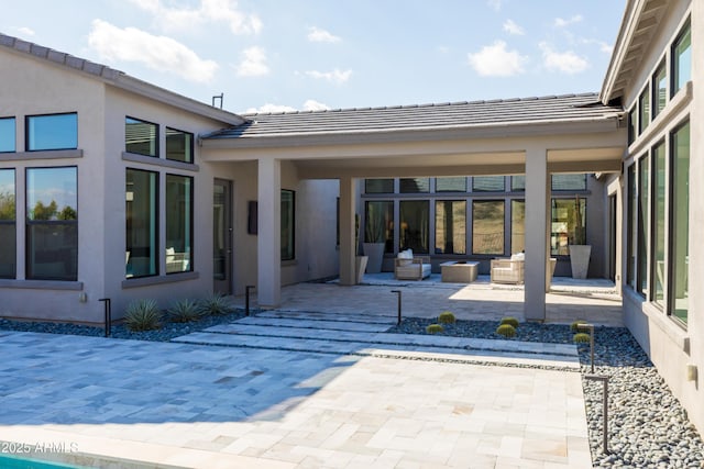 back of house with outdoor lounge area and a patio