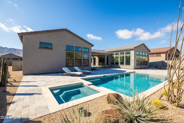 view of swimming pool featuring an in ground hot tub and a patio