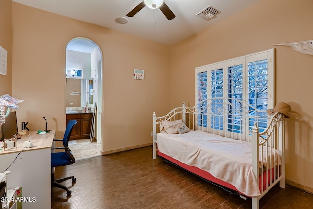 bedroom featuring dark hardwood / wood-style floors, ensuite bath, and ceiling fan