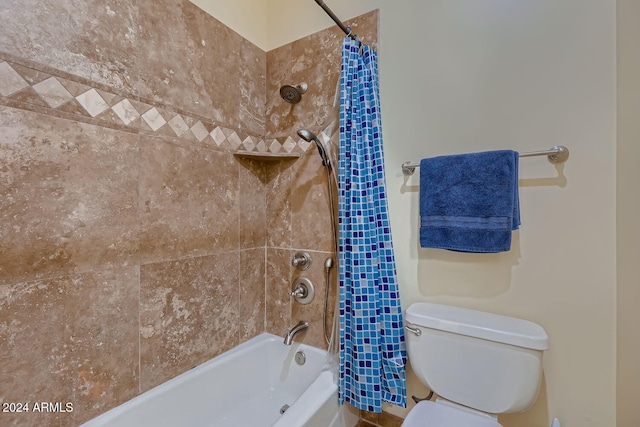 bathroom featuring shower / tub combo with curtain and toilet