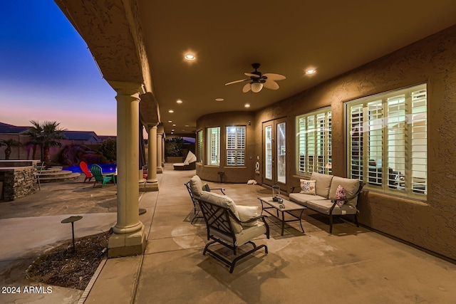 patio terrace at dusk with outdoor lounge area and ceiling fan