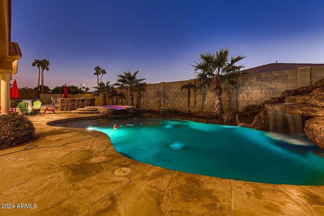 pool at dusk with a patio