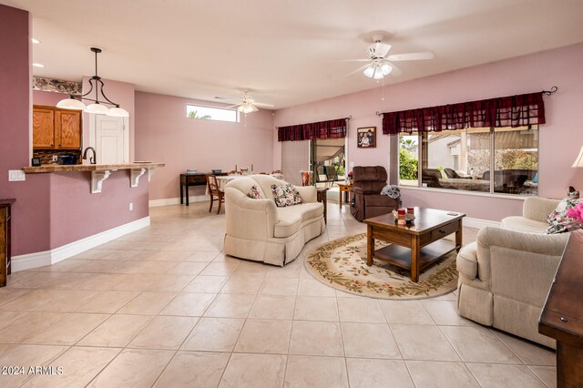 living room with light tile floors, ceiling fan, and sink