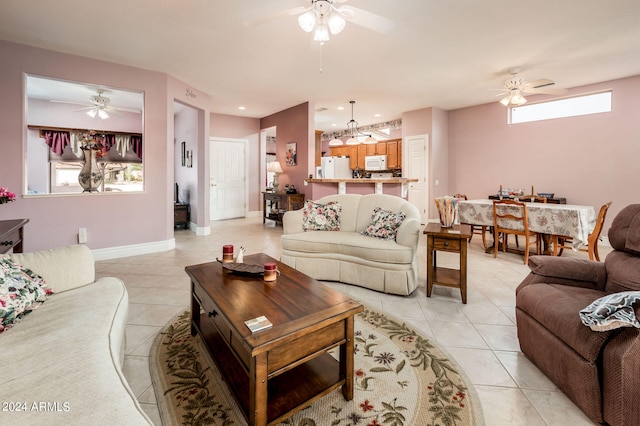 living room featuring plenty of natural light, light tile flooring, and ceiling fan with notable chandelier