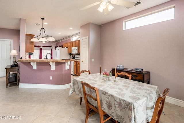 tiled dining space featuring ceiling fan and sink