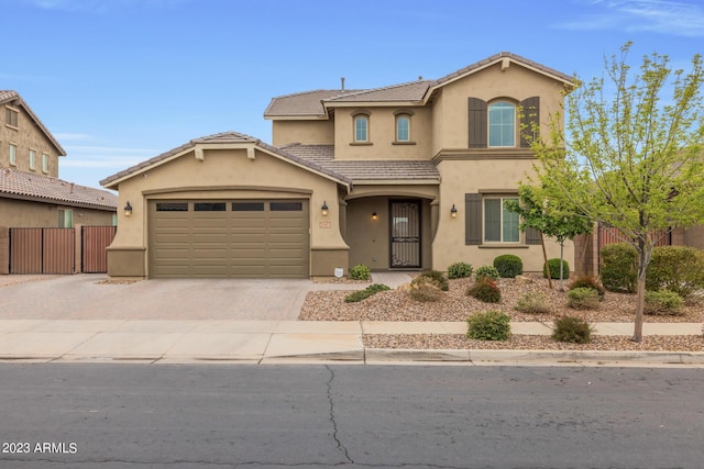 view of front of house with decorative driveway, an attached garage, fence, and stucco siding