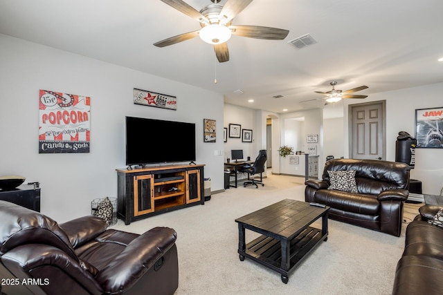 carpeted living area featuring visible vents and a ceiling fan