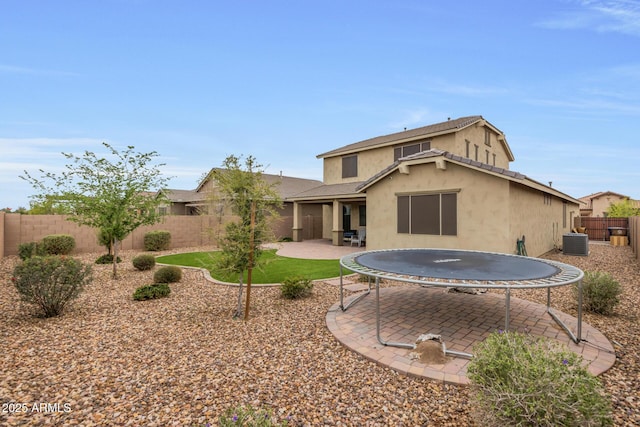 rear view of house featuring a patio area, central air condition unit, stucco siding, and a fenced backyard