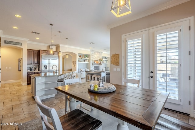 dining area with french doors, built in features, plenty of natural light, and crown molding