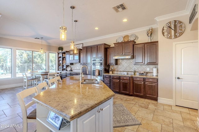 kitchen with crown molding, decorative backsplash, stainless steel double oven, and a spacious island