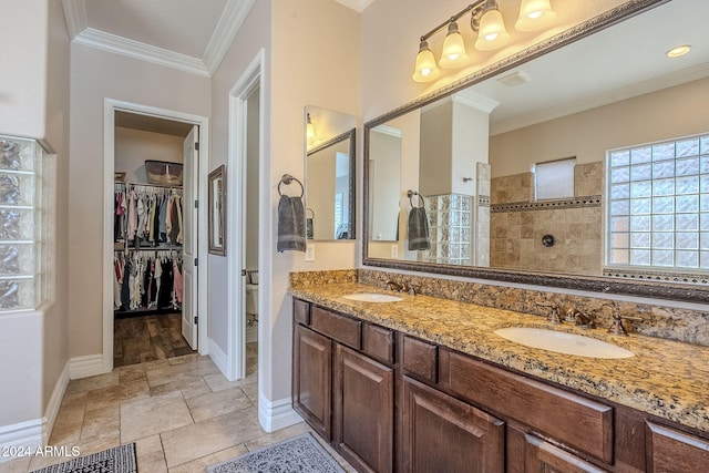 bathroom featuring tiled shower, vanity, and crown molding