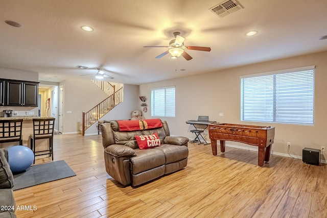 living room featuring ceiling fan and light hardwood / wood-style floors