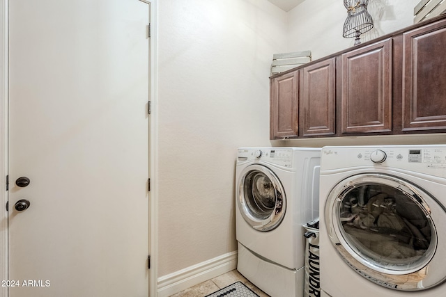 laundry room featuring cabinets, tile patterned flooring, and separate washer and dryer