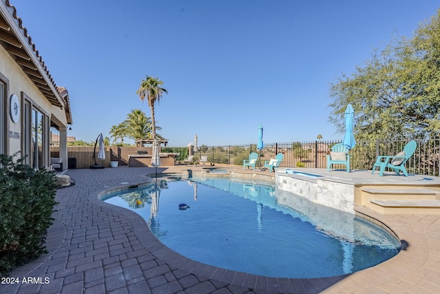 view of swimming pool featuring a patio area and an in ground hot tub