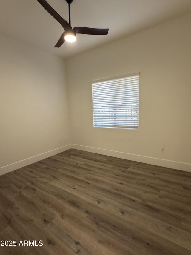 spare room with dark wood-style floors, ceiling fan, and baseboards