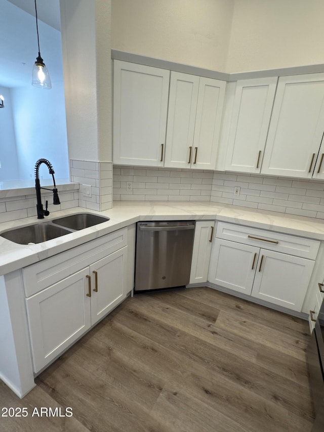 kitchen with sink, stainless steel dishwasher, pendant lighting, decorative backsplash, and white cabinets