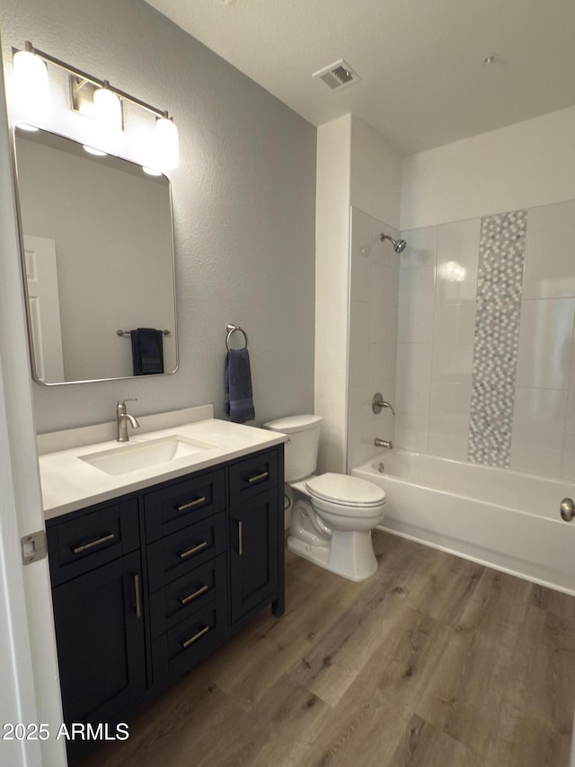 full bath featuring toilet, wood finished floors, vanity, visible vents, and shower / bathing tub combination