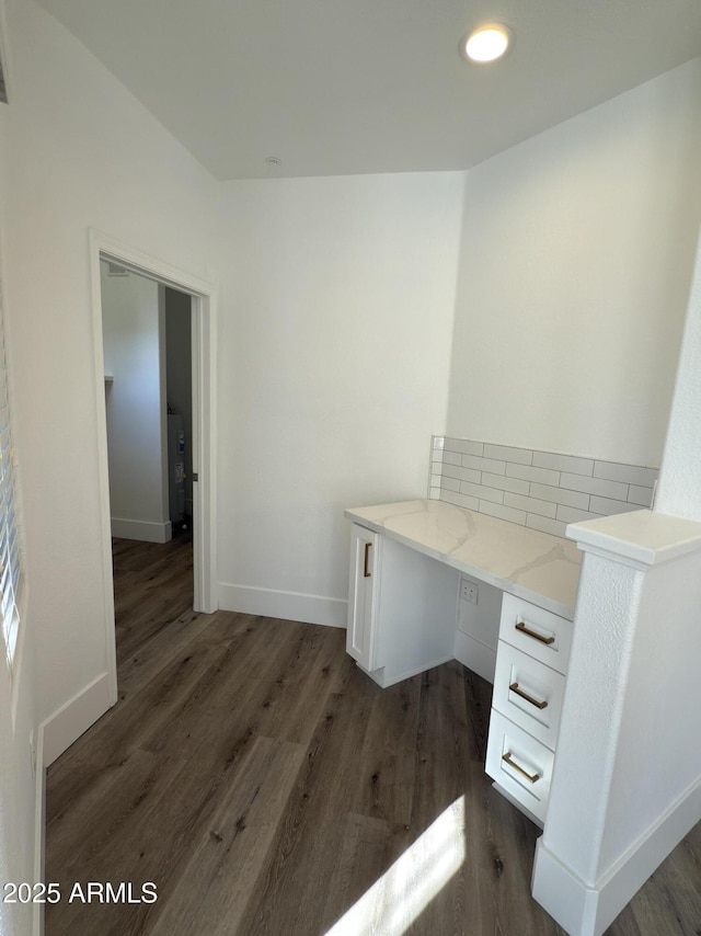 unfurnished office featuring dark wood-style floors, recessed lighting, built in study area, and baseboards