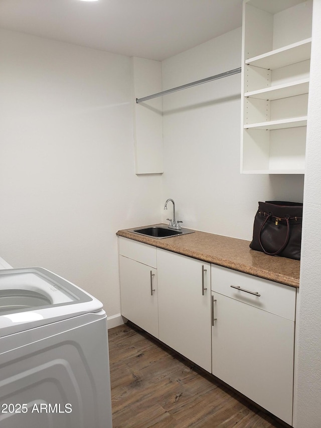 washroom with washer / clothes dryer, dark wood-type flooring, sink, and cabinets