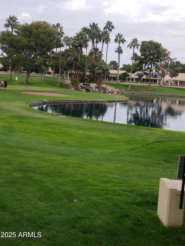 view of home's community with a water view and a yard