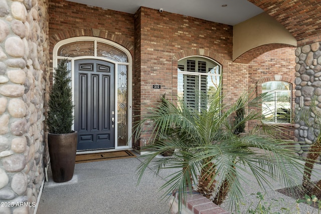 doorway to property featuring brick siding