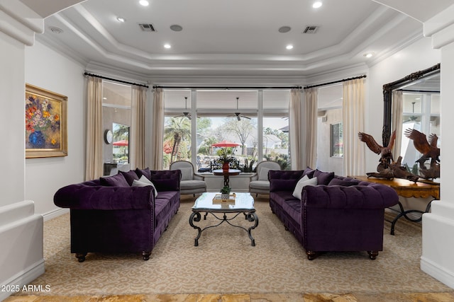 living room with a raised ceiling, visible vents, and crown molding