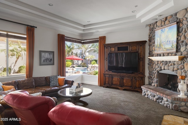 carpeted living room featuring a tray ceiling and a fireplace