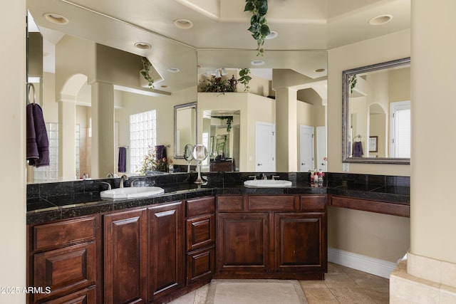 bathroom featuring a sink, ornate columns, and double vanity