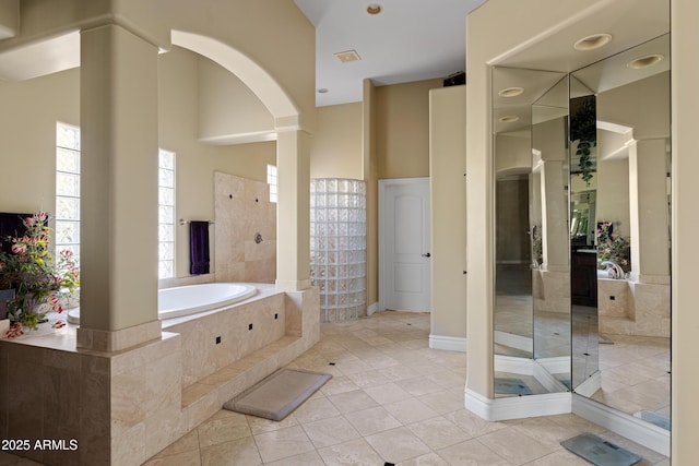 full bathroom with a towering ceiling, a garden tub, tile patterned flooring, and a walk in shower