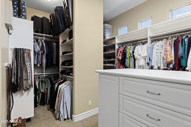 walk in closet featuring light carpet