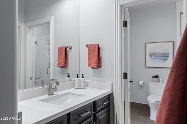 bathroom with toilet, tile patterned floors, a stall shower, and vanity