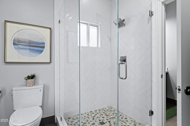 bathroom with a shower stall and toilet