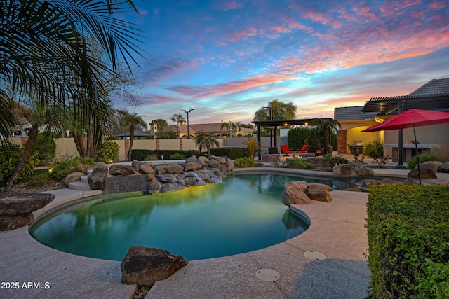 pool at dusk with a patio area, a fenced in pool, fence, and a pergola