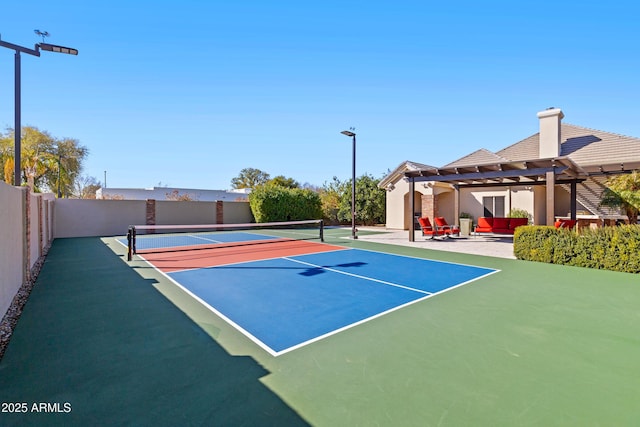 view of tennis court with fence and a pergola