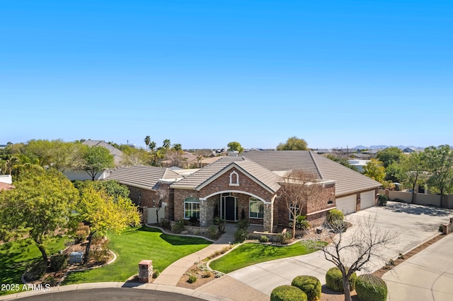 view of front of home with a garage, concrete driveway, stone siding, a tile roof, and a front yard