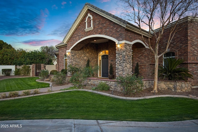 view of front facade featuring brick siding and a front yard