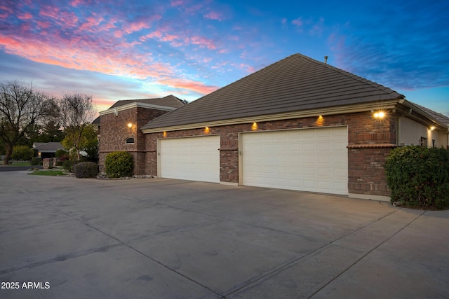 view of front of property with a garage, brick siding, and driveway