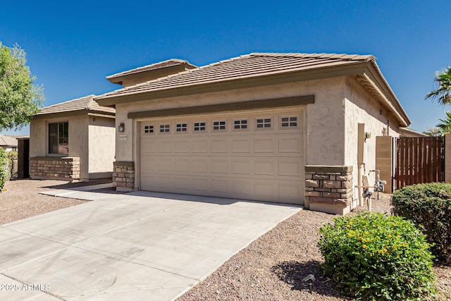 15429 W Ventura St, Surprise, AZ 85379 - view of front facade with stone siding, stucco siding, driveway, an attached garage, and a tiled roof