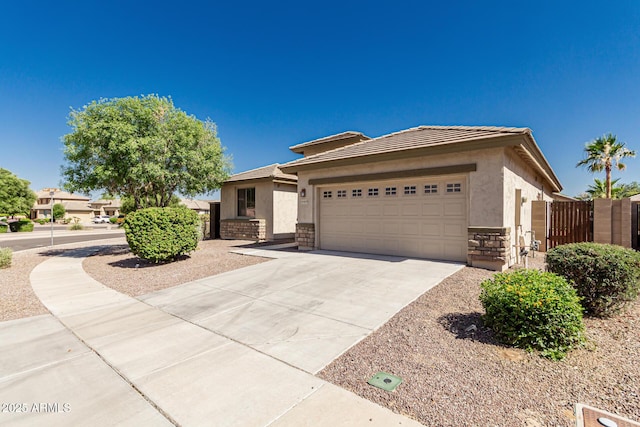 15429 W Ventura St, Surprise, AZ 85379 - view of front of house featuring stucco siding, concrete driveway, a garage, a gate, and stone siding