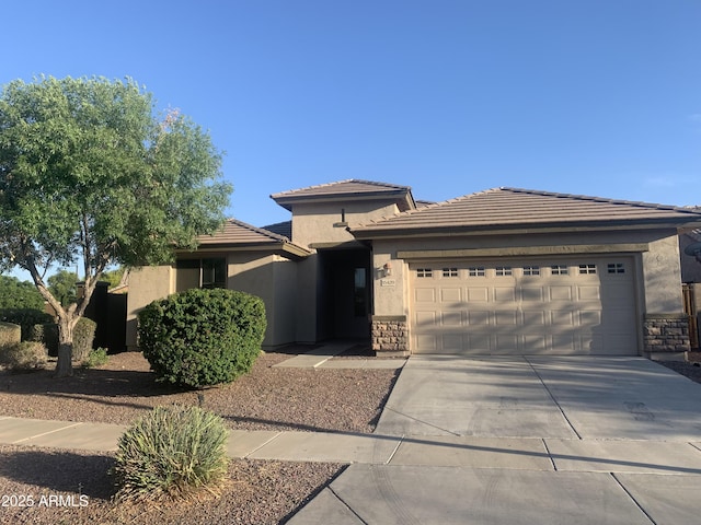 15429 W Ventura St, Surprise, AZ 85379 - view of front facade with a garage, driveway, stucco siding, a tile roof, and stone siding