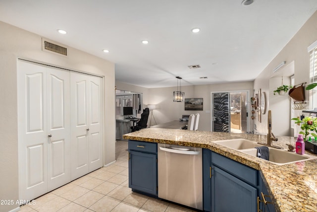 kitchen with visible vents, blue cabinetry, light countertops, and a sink