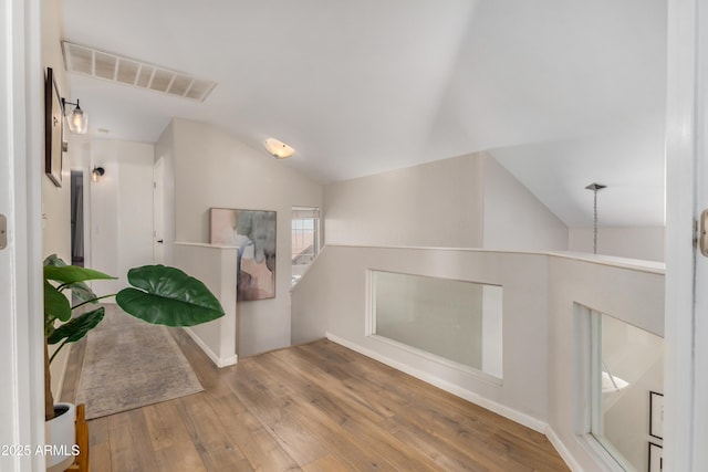 interior space featuring lofted ceiling, wood finished floors, and visible vents