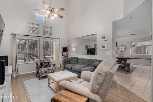 living area featuring wood finished floors, a healthy amount of sunlight, and ceiling fan