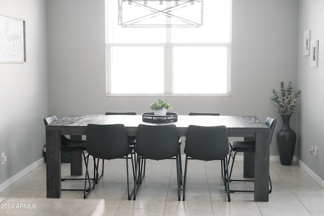 dining area featuring a notable chandelier, a healthy amount of sunlight, and light tile patterned flooring