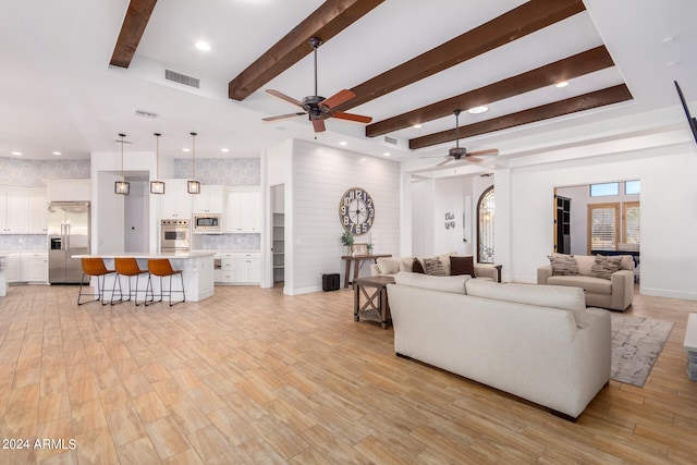 living room featuring beam ceiling, ceiling fan, and light hardwood / wood-style floors