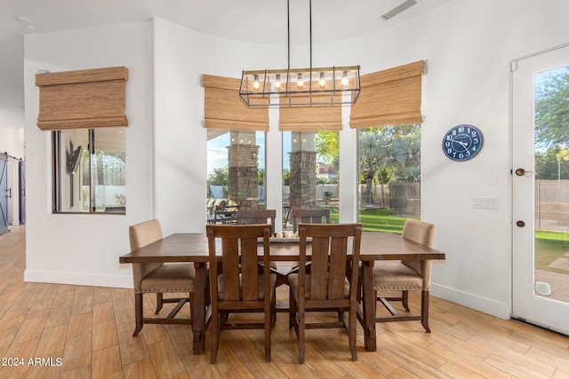 dining room with light hardwood / wood-style floors and an inviting chandelier