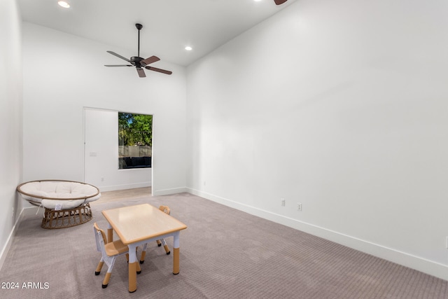 unfurnished room with light colored carpet, high vaulted ceiling, and ceiling fan