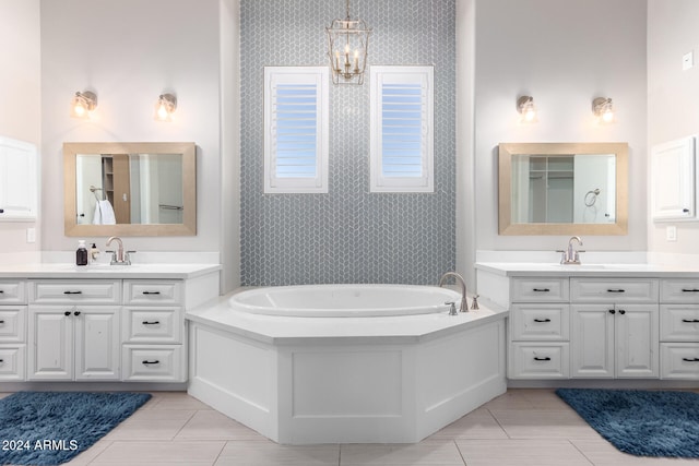 bathroom with a tub, a wealth of natural light, tile patterned flooring, and vanity